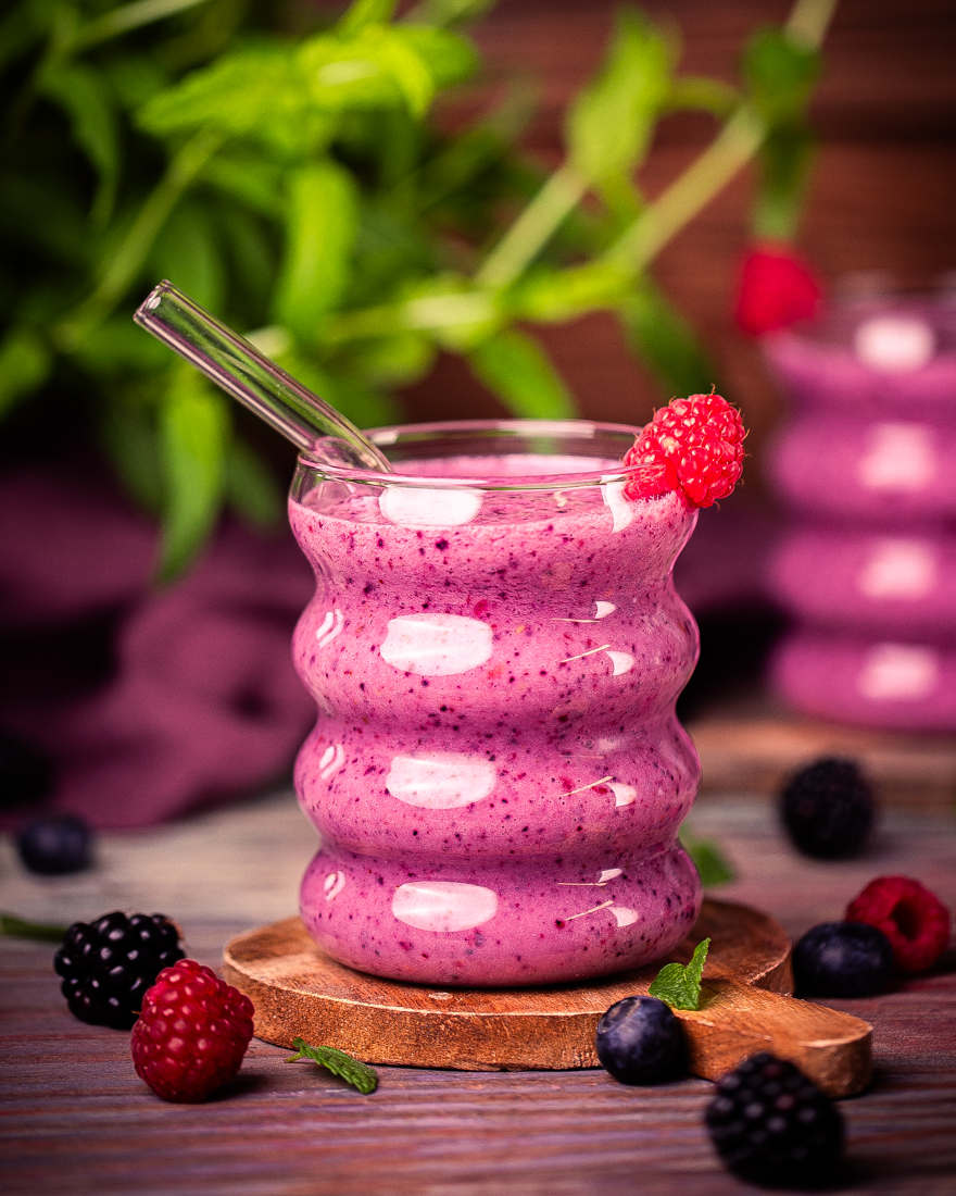 Cremiger Beeren-Proteinshake mit Seidentofu in einem Glas mit frischen Beeren
