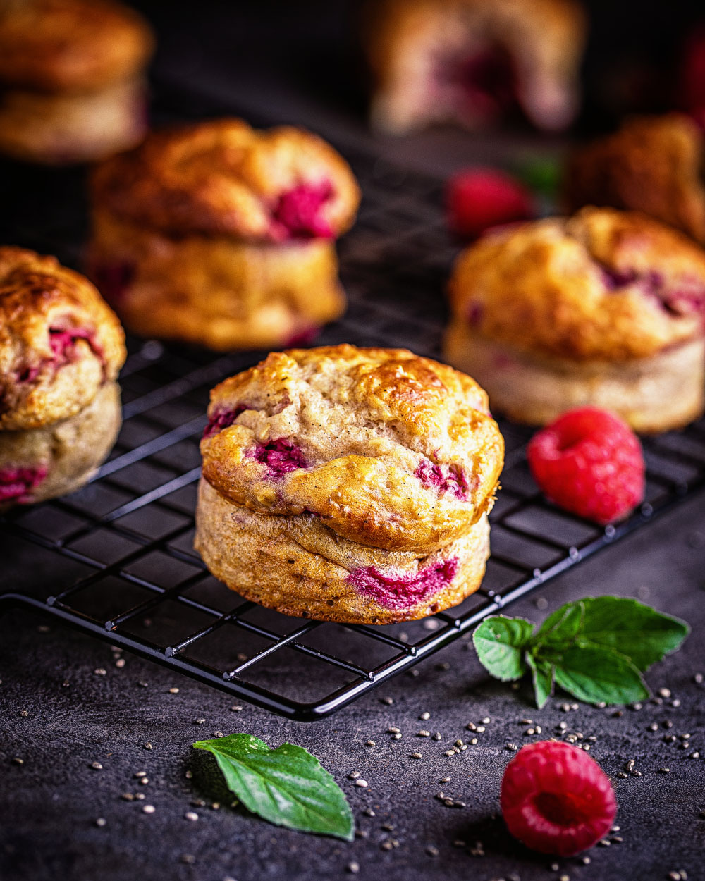 Himbeer-Quark-Muffins auf einem Abkühlgitter mit sichtbaren Himbeerstücken