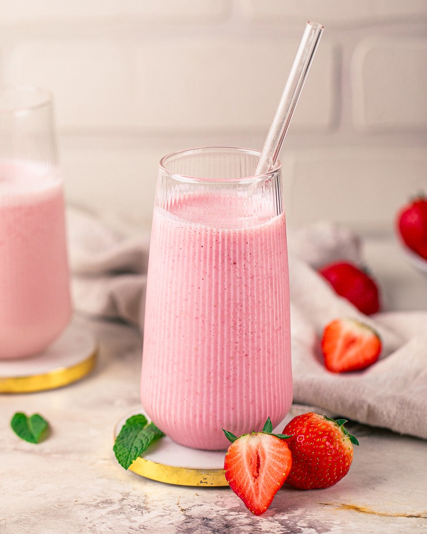 Erdbeer-Proteinshake ohne Proteinpulver im Glas mit frischen Erdbeeren